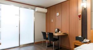 Habitación con escritorio, 2 sillas y 1 cama. en Hotel J Suwon, en Suwon
