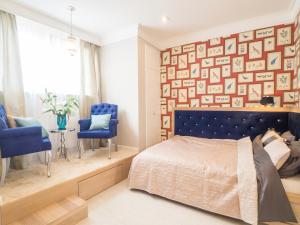 a bedroom with a blue bed and a wall of pictures at Best Apartments Więzienna in Wrocław