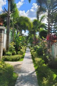 a garden with palm trees and a walkway at Jewelry Resort and Villas Tagaytay in Silang