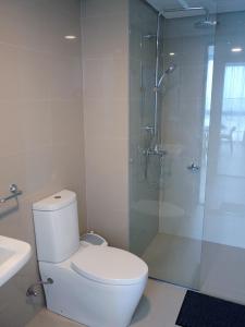 a bathroom with a toilet and a glass shower at Sky High Living at 38 Park Avenue in Cebu City