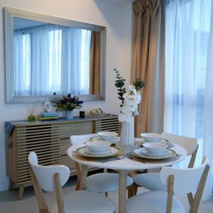 a dining room with a table and chairs and a mirror at Sky High Living at 38 Park Avenue in Cebu City
