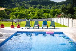 a group of chairs sitting next to a swimming pool at Hodina - Holiday house Rentals in Baia Mare +16 photos