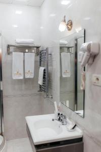 a bathroom with a sink and a mirror and towels at Capitol Hotel Stay in Baku +34 photos