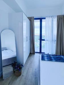 a white room with a bed and a mirror at Sky High Living at 38 Park Avenue in Cebu City +22 photos