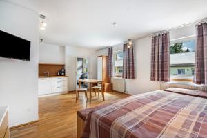 a bedroom with a bed and a table and a kitchen at Ferienwohnung Fenzl in Johanngeorgenstadt