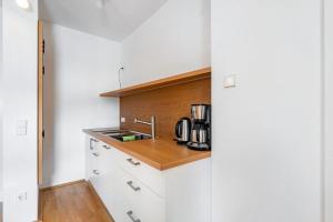 a small kitchen with white cabinets and a sink at Ferienwohnung Fenzl in Johanngeorgenstadt +10 photos