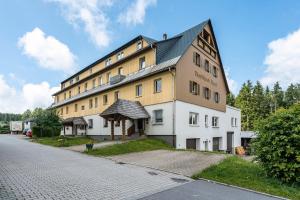 a large building with a pointed roof on a street at Ferienwohnung Fenzl in Johanngeorgenstadt