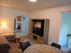 a living room with a large entertainment center with a flat screen tv at Spacieux et Confortable in Compiègne
