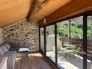 a living room with a couch and a stone wall at Charmante maison cévenole in Aumessas