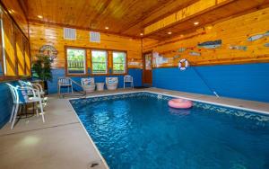 a swimming pool in a house with a wooden ceiling at Dip in the Smokies in Gatlinburg