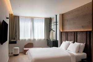 a hotel room with a large bed and a window at Blanco Athens Aparthotel in Athens