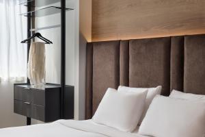 a bedroom with a bed with white pillows and a headboard at Blanco Athens Aparthotel in Athens +19 photos