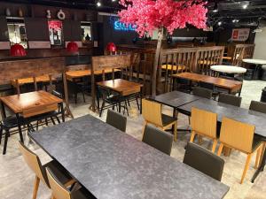 a restaurant with tables and chairs and pink flowers at Hotel Mystays Nagoya Nishiki in Nagoya
