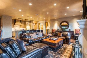 a living room with leather furniture and a kitchen at Ski-in/Ski-out 3 Bedroom Canyons Resort in Park City