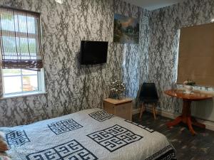 チャーツィーにあるThe Caduceus- Residenceのベッドと壁にテレビが掛かった寝室 +28枚の写真