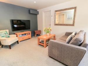 a living room with a couch and a tv at Well Cottage in Malmesbury