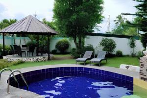 a swimming pool in a yard with chairs and a gazebo at Jewelry Resort and Villas Tagaytay in Silang