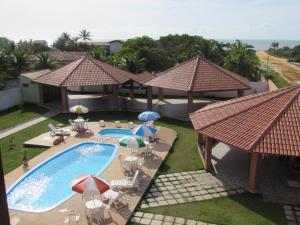 an overhead view of a swimming pool with umbrellas and chairs at Pousada Tropical in Prado