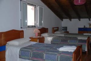 a bedroom with two beds and a window at Alessandro in Sidari