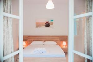 a bedroom with a bed with two towels and two rocks at Nerina Studios Agios Nikitas in Agios Nikitas