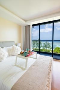 a bedroom with a large bed with a table on it at Lazzlla1BR Beachfront Oceanfront Apartment in Male City