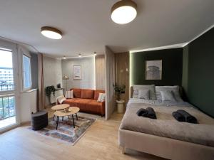 Un dormitorio con una cama grande y un sofá. en Silesian Gold Apartments, en Katowice
