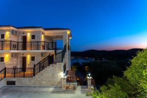 a large house with a staircase leading up to it at night at Pelagos in Parga