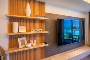 a living room with a tv on a wall at Lazzlla1BR Beachfront Oceanfront Apartment in Male City