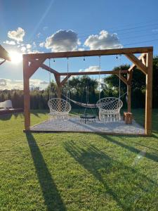 a swing set in a yard with the sun setting at Domek pod Sosnową Górą in Żelazno