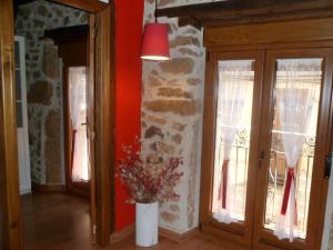 Una habitación con un jarrón con flores. en Alborada, en Sequeros