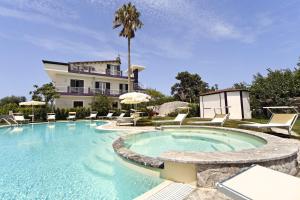 a large swimming pool in front of a house at Selenite in Capo dʼOrlando