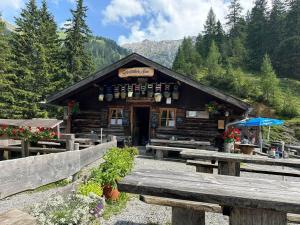 a log cabin with benches in front of it at Fritz Alpchalets - Stablblick in Häselgehr