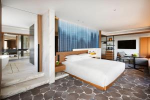 a bedroom with a large white bed and a bathroom at Hyatt Regency Tokyo in Tokyo