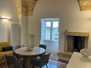 a living room with a table and chairs and a fireplace at La Torretta dimora storica in Montesano Salentino