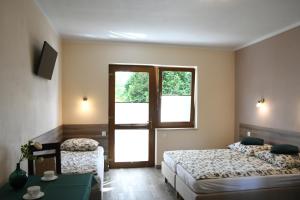 a bedroom with two beds and a sliding glass door at Pokoje gościnne GRYF in Rewal