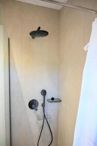 a shower with a shower head and a shower head at Ifigenia VIlla Sissi in Sissi +19 photos