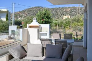 a balcony with a couch and chairs and a table at Ifigenia VIlla Sissi in Sissi