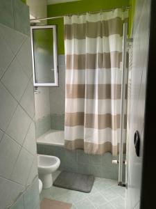 a bathroom with a shower curtain and a toilet at I colori della casa di Gio in Grugliasco +12 photos