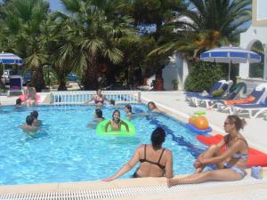 a group of people sitting in a swimming pool at Alessandro in Sidari