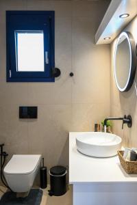 a bathroom with a sink and a toilet and a mirror at Ifigenia VIlla Sissi in Sissi