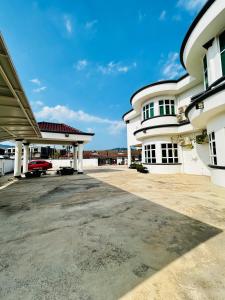 a large white building with a parking lot at Lestari Inn Boutique Residence - Private Parking in Kuantan