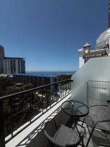 バトゥミにあるNice Apartments Batumiのテーブルと椅子と海のあるバルコニー