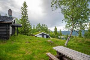 a wooden bench sitting on top of a green field at Trysilfjellet Sør 480 in Trysil