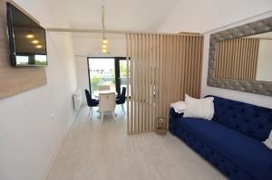 Una sala de estar con un sofá azul y una mesa. en Daren Apartment, en Eforie Nord