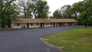 Un edificio con un estacionamiento enfrente. en Budget Host Inn, en Detroit Lakes