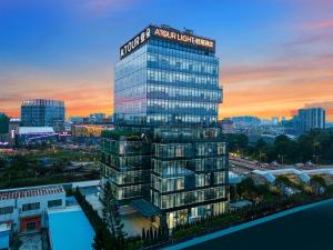 Un edificio alto con un cartel encima. en Atour Light Hotel Guangzhou Panyu Chimelong Wanbo Business District, en Guangzhou