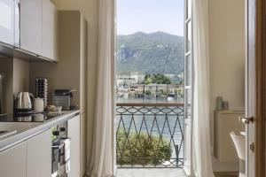 a kitchen with a balcony with a view of the water at Orta Paradise 4 in Orta San Giulio