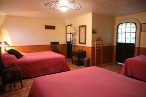 a hotel room with two beds and a window at Hotel del Carmen in Tlalpujahua de Rayón