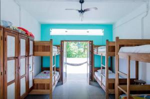 Habitación con 3 literas y puerta. en Casa Bacarirá - Floresta com Yoga e Café da Manhã Vegano, en Camburi 91 fotos más