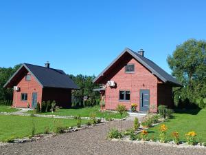 a red house with a black roof and a garden at Domki pod szybowiskiem in Lesko